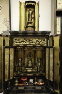 Japanese cabinet for two gilded statues of the Buddha, one inside the cabinet and the other on the top of the cabinet.
