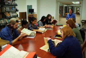 Students and faculty look at books in the Asian Library