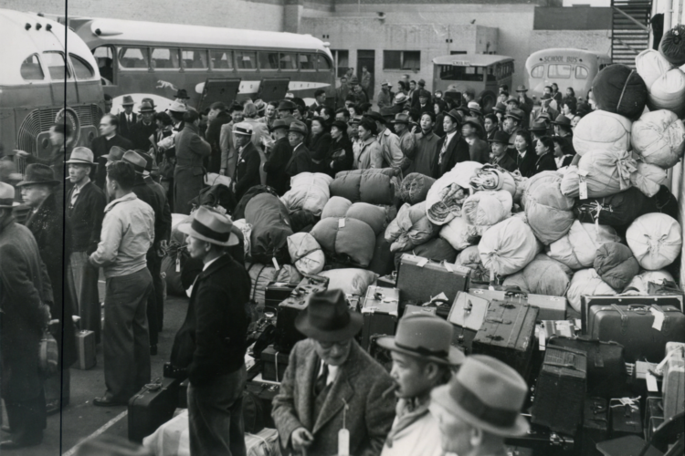 Crowd of individuals with luggage waiting to board buses