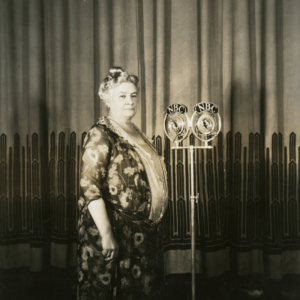 Photo of Ernestine Schumann-Heink standing next to two NBC microphones